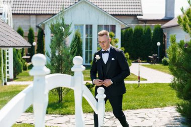 Şık Smokinli Şık Damat Resimli Bahçede Yürüyüş Sunny Day 'de.