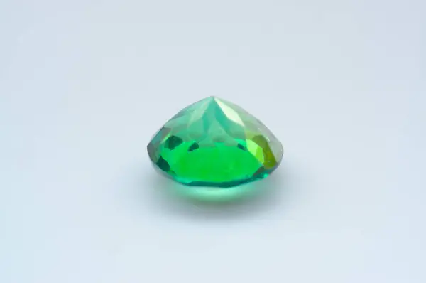 stock image Elegant Emerald Gemstone on Minimalist White Background Showcasing Vibrant Green Hue and Faceted Surface.