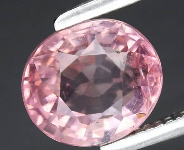 İnce cımbızla Işıldayan Pembe Safir Taşının Büyüleyici Yakın Çekimi.