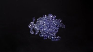 Pürüzsüz siyah bir yüzey üzerinde pırıl pırıl Mor Gemstone 'ların zarif dizilişi