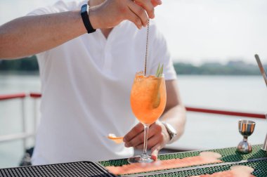 Ferahlatıcı Yaz Kokteyli Güneşli bir günde bir barmen tarafından teknede hazırlanıyor .
