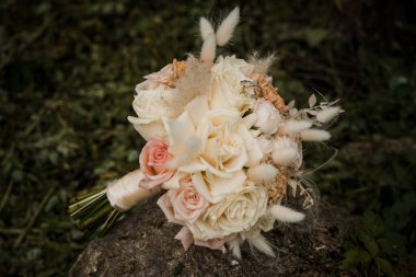 Yumuşak Pastel Güllerin Zarif Gelini ve Doğal Bir Arkaplan Karşısında Kurumuş Çiçek Aksanları.