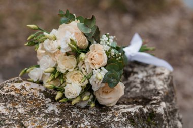 Krem Güllü Zarif Gelin Buketi ve Kırsal Taş Arkaplanda Ökaliptüs.