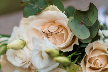 Altın Yüzükler ve Yumuşak Çiçek Aksanlı Zarif Düğün Buketi.