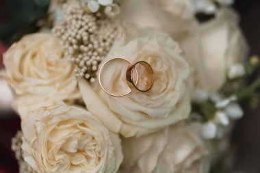 Zarif düğün yüzükleri narin çiçek aksanlı yumuşak krem güllere dayanır..