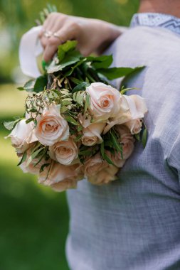 Yumuşak Pembe Güllerin Romantik Buketi Yeşiller Arkasında Zarifçe Tutuldu.