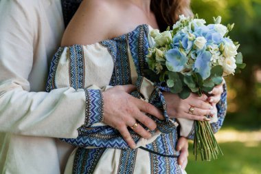 Romantik Kucaklaşma: Güneşli Açık Hava Sahnesinde Güzel Çiçek Buketi Tutan Sevecen Bir Çift.