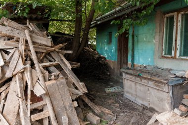 Terk Edilmiş Ev Doğa ve Kereste Döküntüleriyle çevrili.