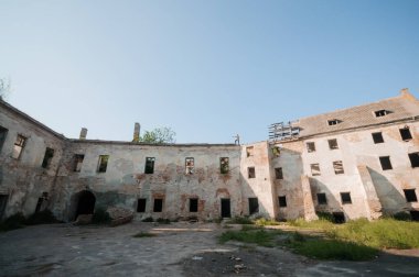 Abandoned Ruins of a Weathered Historical Building Amidst Overgrown Nature. clipart