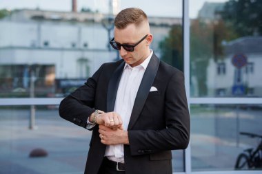 Siyah Giysili Zarif Adam Dışarıda Zaman Kontrol Ediyor.