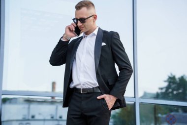 Güneş Gözlüklü Zarif İş Adamı Modern Bir Binanın Dışında Gezici Bir Konuşmaya Girdi.