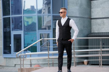 Modern Urban Caddesi 'nde Güneş Gözlüklü Şık Genç Adam Güvenle Yürüyor.