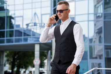 Şehir Merkezinde Modern Mimariyle Telefonda Zarif İşadamı.