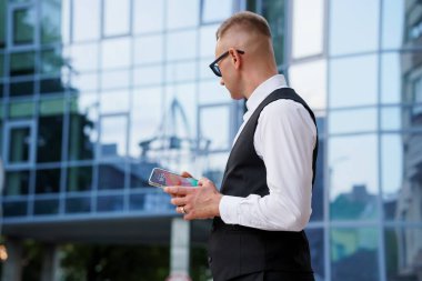 Modern Cam Binasına Karşı Akıllı Telefonlu Şık İşadamı.