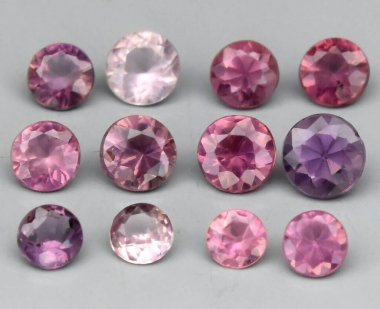 Yumuşak Gri Arkaplanda Sergilenen Canlı Doğal Pembe ve Mor Gemstone Koleksiyonu.