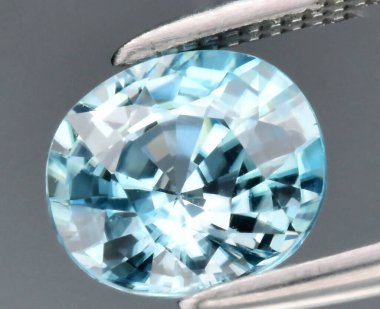 Exquisite Oval-Cut Aquamarine Set Against a Soft Gray Background Showcasing Its Brilliant Clarity and Color Depth. clipart