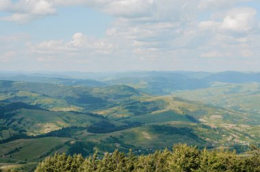 Mavi Gök Altında Yuvarlanan Tepelerin Sakin Panoramik Manzarası.