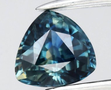 Exquisite Triangular Blue Gemstone with Intricate Faceting and Sparkling Depth. clipart