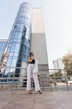 Şık Çizgili Modern İşkadını Cam Bir Binaya Karşı Emin Bir Poz Veriyor.