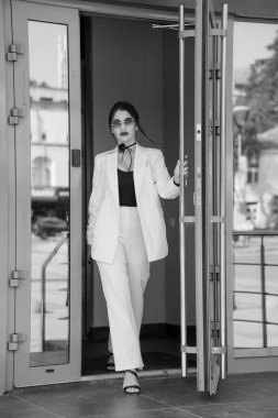 Kendine güvenen İş Kadını Modern Ofis Binasından Şık Çizgili Takım Elbiseyle Çıkıyor.
