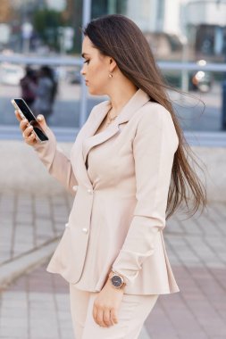 Şık Giyimli İş Kadını Bir Şehir Ayarında Mobil İletişim Kuruyor.