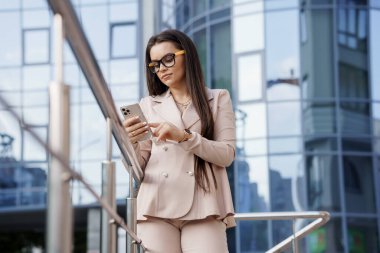 Modern Şehir Arkaplanına Karşı Mobil İletişim Kuran Zarif İş Kadını.