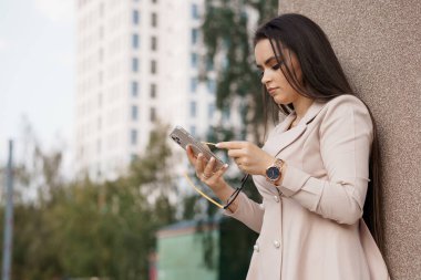 Modern Şehir Arkaplanına Karşı Mobil İletişim Kuran Zarif Genç Kadın.