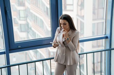 Profesyonel Zarafet: Panoramik Pencere Tarafından Düşünceli İletişim Kuran Bir İş Kadını.