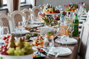 Şık Yemek Sofrasında Çeşitli Tabaklar ve Taze Meyvelerle Zarif Masa Seti.