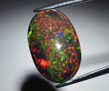 Büyüleyici Çok Renkli Opal Gemstone Ateşli Kırmızı ve Yeşil Benekleri Gösteriyor.