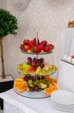 Enfes Üç Katmanlı Meyve Gösterimi Taze Mevsimlik Ürünlerle süslenmiştir.