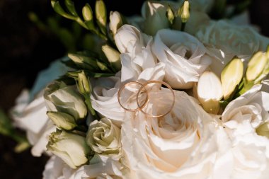 Zarif Alyanslar Beyaz Güller Buketinde Dinleniyor.