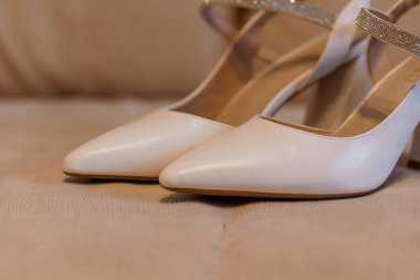 Yumuşak Arkaplanda Parıldayan Kayışlarla Zarif Beyaz Yüksek Topuklar.