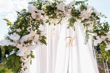 Beyaz Güller ve Parlak Gökyüzüne Karşı Yeşillik ile Zarif Çiçekli Düğün Kemeri.