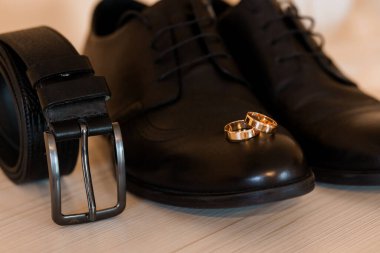 Resmi Ayakkabılar, Altın Yüzükler ve Parlak Kemer içeren Zarif Düğün Giysileri.