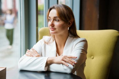 Reflective Woman in a Modern Cafe Setting. clipart