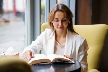 Rahat Kadın Rahat Kafe Ayarlarında Kitap Okuyor.