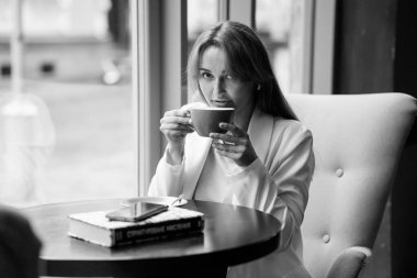 Samimi bir kafede kahve içen zarif bir kadın..