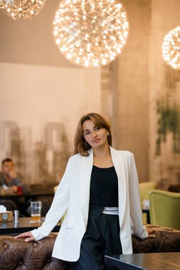 Modern Kafe 'de Sanatsal Işıklı Zarif Kadın Pozu.