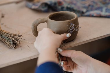 Kurumuş çiçekler ve zanaatkar dokunuşlarla el yapımı Clay Bardağı..