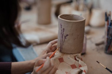 Artisan Creating a Handcrafted Clay Vase with Lavender Designs. clipart