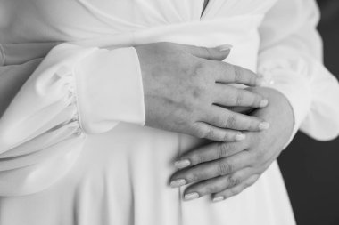 Beklenen Neşe: Hamile Bir Kadının Ellerinin Bebek Şişkinliğinde Yakın Çekimi.