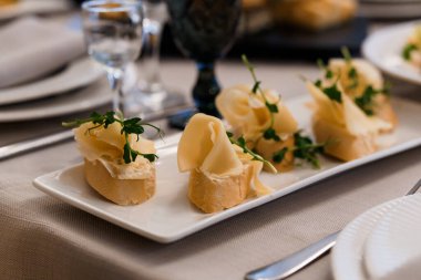 Zarif bir gurme aperatif tabağı. Zarif bir şekilde düzenlenmiş ekmek ve peynirle süslenmiş yeşillikler..