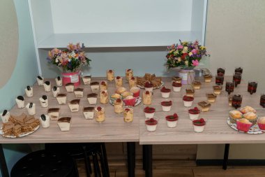 Bir dizi Tatlı İkramları ve Çiçek Düzenlemeleri içeren Lezzetli Tatlı Masası.