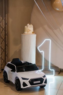 Elegant First Birthday Celebration with Toy Car and Cake Decoration. clipart