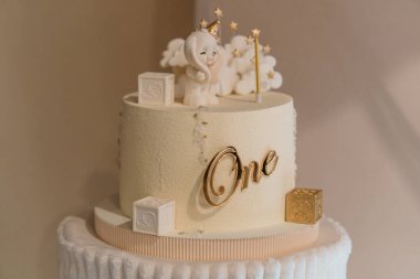 Cherubic Dekorasyonu ve Altın Aksanlı Zarif İlk Doğum Günü Pastası.