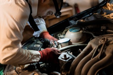 Mechanic in a White Shirt and Tie Working on Car Engine with Flashlight. clipart