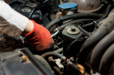 Araç ve Eldivenlerle Motor Bileşenleri Üzerinde Çalışan Tamirci.