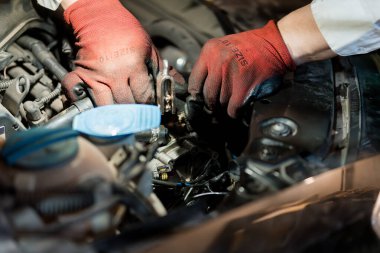 Eller Kırmızı Eldivenli Araba Motor Mekanikleri üzerinde çalışıyor.