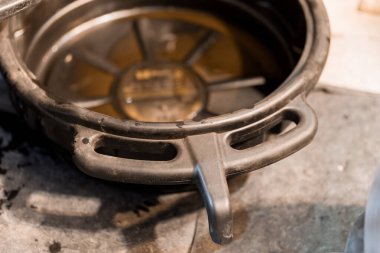 Metalik bir yüzeye arta kalan yağla yerleştirilmiş paslı bir yağ tavası..